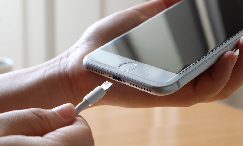 Woman Plugging Lightning Cable into iPhone