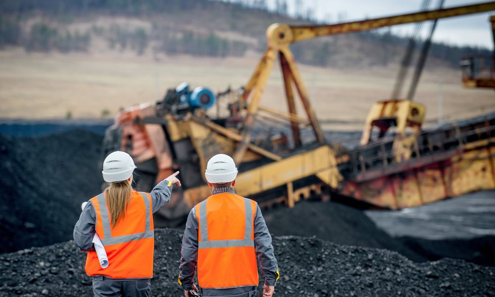 Two Miners Standing In Front Of Open Pit
