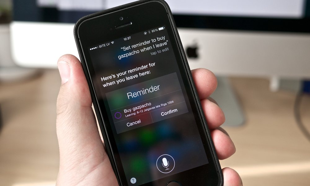 Man Holding iPhone setting Reminder with Siri