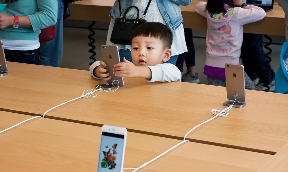 Chinese Boy Looking at iPhone In Apple Store