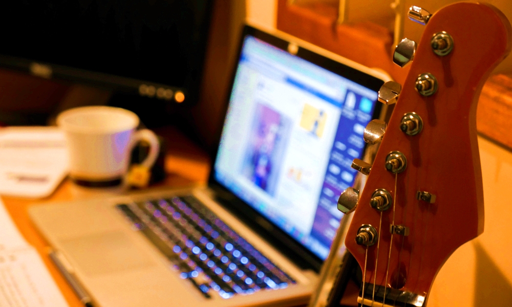 Guitar with MacBook in background