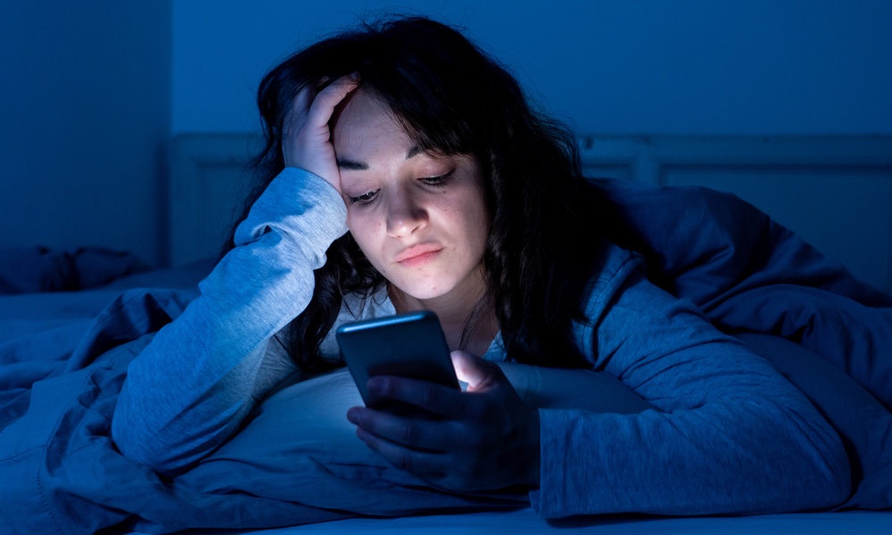 frustrated woman using smartphone at night