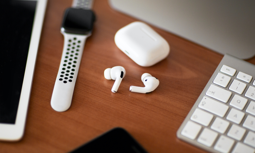 AirPods Pro on desk with Apple Watch, iPad, and Keyboard