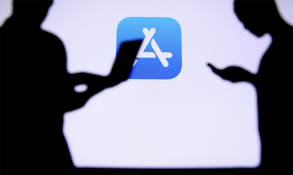 Two silhouetted people in front of App Store logo